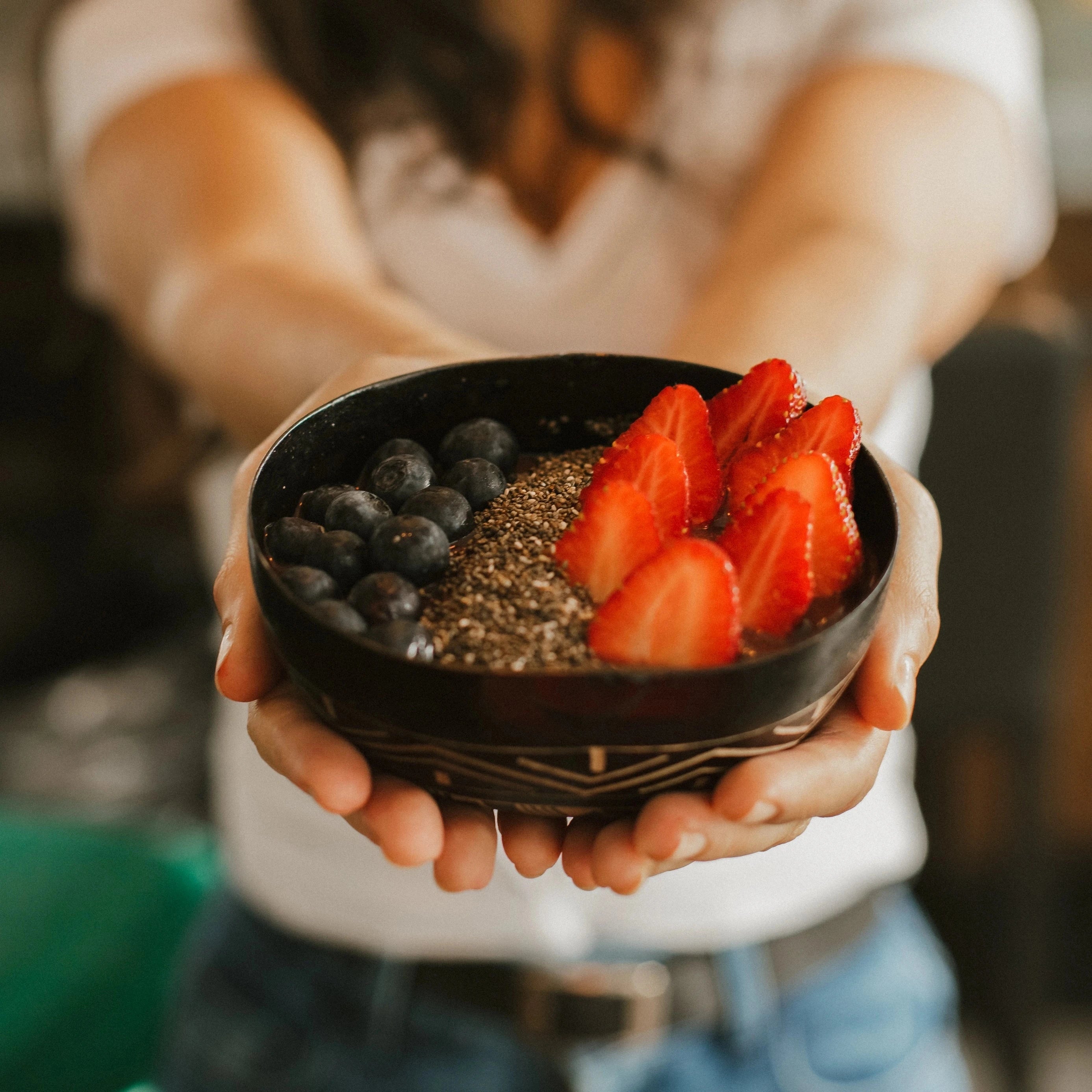 Pessoa segurando bowl de açaí